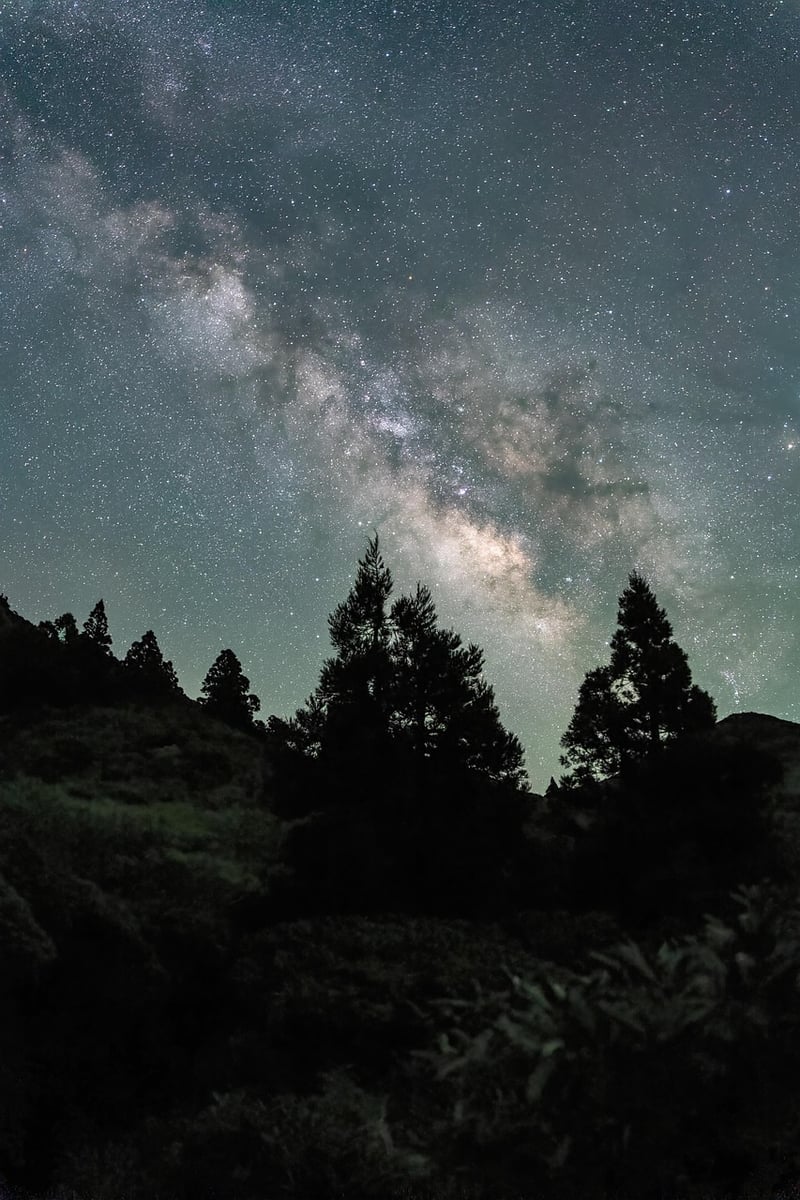 Person practicing yoga on a cliff overlooking the Milky Way